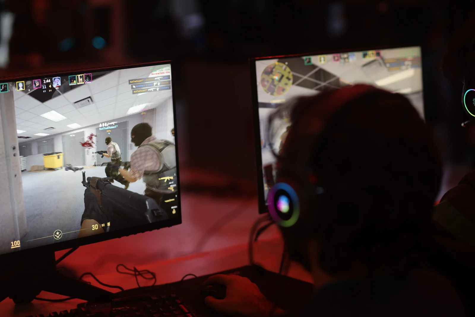A headset-wearing competitor playing a tactical shooter at Experia VII